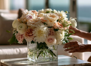 Luxury faux floral arrangement with blush garden roses, ivory dahlias, ranunculus, and soft neutral blooms being styled by hand in a modern coastal home by True Bloom Floral™