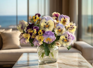 Elegant faux pansy floral arrangement featuring pastel purple, cream, and yellow blooms in a modern glass vase by True Bloom Floral™