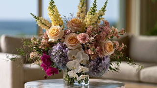 Large luxury faux floral arrangement featuring pastel garden roses, hydrangeas, white orchids, and yellow snapdragons styled in a glass vase by True Bloom Floral™