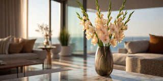 Faux peach gladiolus stems in a glass vase styled in a bright modern interior with warm neutral tones