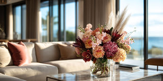 Fall floral arrangement with warm-toned hydrangeas and textured stems in a sunlit modern interior