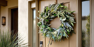 Natural greenery wreath with eucalyptus and mixed foliage styled on a modern front door entrance