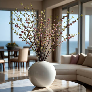 46 Inch tall faux Hoary Willow branch spray stem stayed in a glossy round white vase on a marble coffee table in a luxury home with costal views