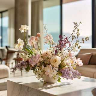 Summer faux floral arrangement style on a marble table in a luxury  modern home with ocean views in the background
