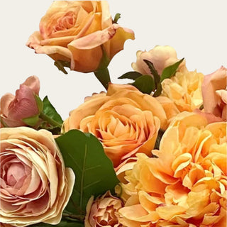 Close Up view of the Apricot Garden premade floral arrangement shown in a gold metal vase with apricot, peach, cream, and blush mixed real touch and faux florals for coffee table, dining table, entry console, kitchen island, and bedroom dresser styling.