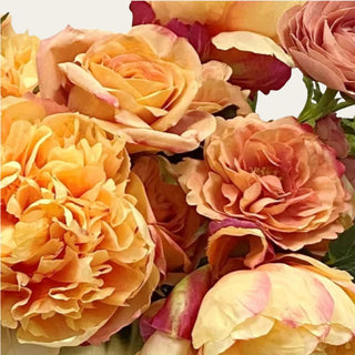 Close Up view of the Apricot Garden premade floral arrangement shown in a gold metal vase with apricot, peach, cream, and blush mixed real touch and faux florals for coffee table, dining table, entry console, kitchen island, and bedroom dresser styling.