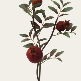 Close-up of an artificial burgundy faux dried pomegranate branch featuring realistic fruit, natural foliage, and detailed branching for designer floral styling.
