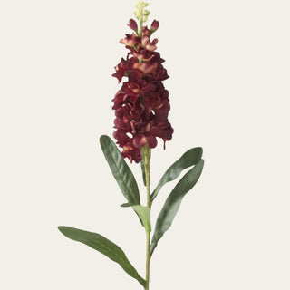 Close-up of an artificial burgundy stock stem featuring realistic faux blooms with a soft flocked finish and lifelike botanical detail.