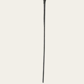 Detail of the long black artificial eucalyptus stem showing its slender structure below the branching foliage.