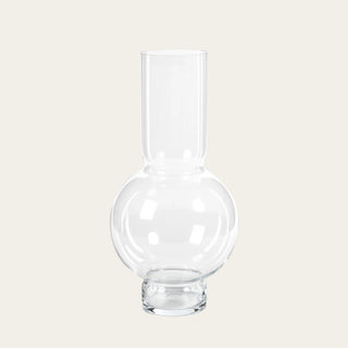Clear Monceau Glass Vase with rounded glass base and tall cylindrical neck, used to style faux tulips, hydrangeas, roses, peonies, greenery, and year-round floral arrangements.
