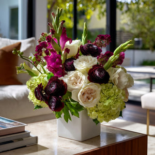 Dark purple/plum True Bloom Floral  ranunculus floral arrangement styled on a marble table in a luxury modern home 