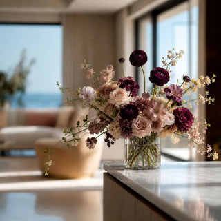 Dark purple/plum True Bloom Floral  ranunculus floral arrangement styled on a marble table in a luxury modern home 