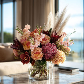 Fall arrangement of mixed florals styled on a marble table of a modern decor style home 