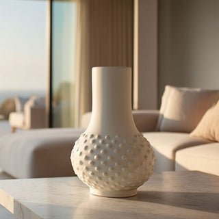 White textured ceramic vase with raised dot detail on a marble table, styled in a modern coastal living room with ocean view, used as a floral vase pairing guide header image
