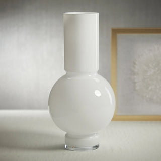 Glossy White Monceau Glass Vase shown in a studio setting with a sculptural rounded base and tall neck, ideal for clean faux floral arrangements with branches, tulips, hydrangeas, peonies, roses, and greenery.