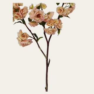 Close-up of light peach and linen real touch blossom branch with layered petals, warm peach centers, realistic faux leaves, and natural branch styling for designer floral arrangements.