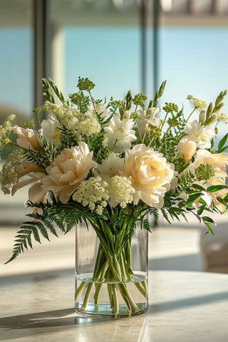 Step 5 of how to build a floral arrangement the final step of an arrangement styled on a marble table in a modern luxury home