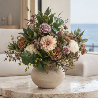 Mixed Eucalyptus Bundle of 3 Stems styled in a neutral floral arrangement with cream dahlias, mauve roses, white blooms, green berries, soft filler stems, and layered greenery in a stone vessel on a marble coffee table in a bright coastal living room.