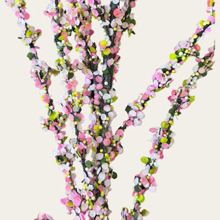 Close-up detail of pink confetti blossom branch stem with layered faux blossoms, soft white accents, textured branching, and playful spring floral styling.