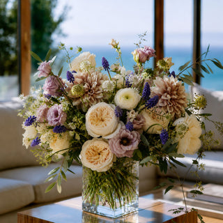 Full luxury floral arrangement in a sunny coastal california home. Arrangement is full of soft late summer and early fall colors, including mauve, soft yellows and dark purple Hyacinth florals