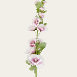 Close-up detail of purple and white faux hollyhock blooms showing layered petals, soft tonal variation, and velvet-textured foliage for romantic garden-inspired floral arrangements.