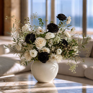 Luxury faux black rose floral arrangement featuring Real Touch black garden roses, ivory roses, white ranunculus, lisianthus, olive branches, and preserved botanicals styled in a modern ceramic vase for elegant home décor.