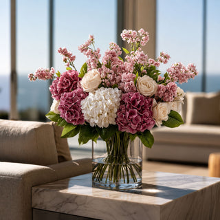 Dark pink True Bloom real touch hydrangea stems styled in a glass vase with white hydrangeas, blush roses, and pink stock, creating a full year-round arrangement that works beautifully in spring, summer, fall, and winter thanks to its rich pink color and versatile floral palette.