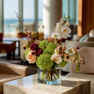 Green real touch hydrangea stems styled in a glass vase with soft neutral florals and greenery, creating a warm spring, summer, or early fall arrangement that works beautifully with ivory, champagne, cream, and muted seasonal tones.