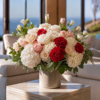 The Red True Bloom Real Touch Duchess roses styled in a spring and summer faux floral arrangement with white hydrangeas, soft blush roses, greenery, and a clear glass vase.