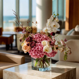 Two toned mauve pink real touch hydrangea stems styled in a glass vase with soft neutral florals and greenery, creating a warm spring, summer, or early fall arrangement that works beautifully with ivory, champagne, cream, and muted seasonal tones.