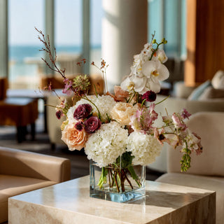 White real touch hydrangea stems styled in a glass vase with soft neutral florals and greenery, creating a warm spring, summer, or early fall arrangement that works beautifully with ivory, champagne, cream, and muted seasonal tones.