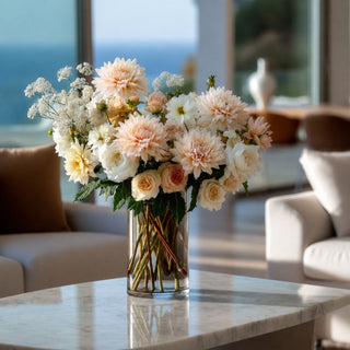 Light Peach true bloom real touch dahlia stem styled in a beautiful floral arrangement  set in a clear glass vase on a marble coffee able in  luxury modern coastal home. 