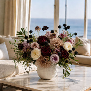 Luxury burgundy and taupe faux floral arrangement with real touch roses, dahlias, black billy balls and olive branches in a white ceramic vase by True Bloom Floral.