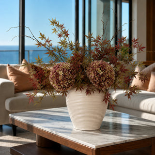 Burgundy and green Japanese maple leaf sprays styled with green and antique brown hydrangeas in a tall brown vase, creating a large layered fall arrangement.