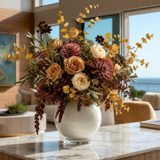 An organic, asymmetrical, and airy floral arrangement—lots of negative space, with the yellow eucalyptus dancing above the flowers instead of creating a dense dome. A floral designer arranged freshly gathered fall stems.