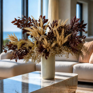 Luxury fall floral arrangement by True Bloom Floral featuring burgundy foliage, golden wheat and cream botanical stems in an ivory vase, styled in an elegant California coastal-inspired living room