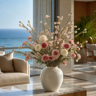Faux pink chamelaucium stems styled in a neutral vase with roses and soft florals, creating an airy arrangement filled with movement, texture, and romantic spring-inspired color.