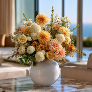 White snowball flower stems styled with peach, cream, and soft yellow florals in a rounded white vase for a full layered arrangement that works beautifully year-round because white blooms pair easily with seasonal greenery and transitional floral palettes.