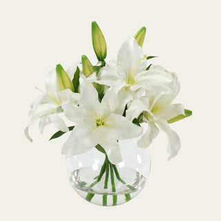 White Faux Casablanca Lily Arrangement in a clear glass vase with realistic faux water, featuring open white lily blooms and fresh green buds for elegant coffee table, console table, nightstand, and entryway styling.