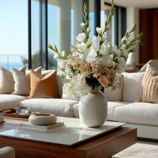 White True Bloom gladiolus stems styled in a white vase with blush roses and soft neutral faux florals on a wood coffee table in a light-filled living room
