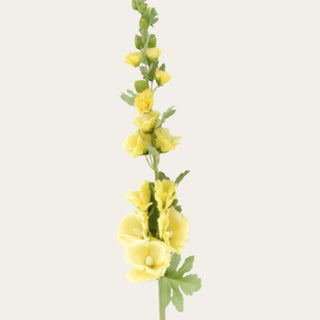 Close-up detail of yellow faux hollyhock blooms showing layered petals, soft white accents, and velvet-textured foliage for airy garden-inspired floral arrangements.