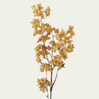 Close-up of polyester cherry blossoms in golden yellow, ochre and warm orange tones with softly shaped petals on a Traditional Faux flowering branch.