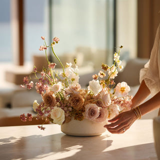 True Bloom Floral arrangement in a white vase on a marble table  of a luxury home with a blurred indoor background