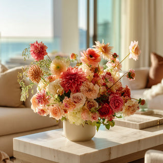 arrangement of flowers on a coffee table with a cityscape view in the background