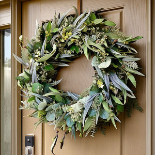 Natural greenery wreath with eucalyptus and mixed foliage styled on a modern front door entrance