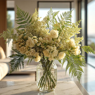 Real touch green lace fern styled with ivory roses, airy filler florals, and layered greenery in a clear glass vase for a soft modern floral arrangement that works beautifully year-round because the airy fern texture layers naturally with both seasonal blooms and transitional greenery.