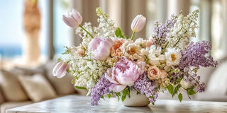 luxury true bloom floral arrangement of tulips and mixed florals styled on a luxury table of a modern home with a blurred background
