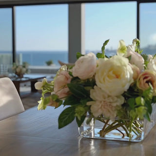 howcasing the 25 Inch Cafe Au Lait True Bloom Real Touch Floral Arrangement featuring ivory peonies, cream garden roses, blush anemones, dahlias, hellebores, and fresh greenery arranged in a premium glass vase with permanent acrylic water. Luxury ready-made floral centerpiece styled on a dining table, highlighting realistic movement, layered textures, designer composition, and year-round elegance for spring, summer, fall, winter, and holiday home décor.