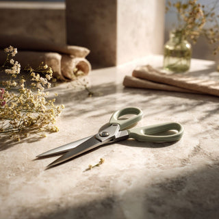 floral stem cutters sitting on a marble table top with floral stems nearby