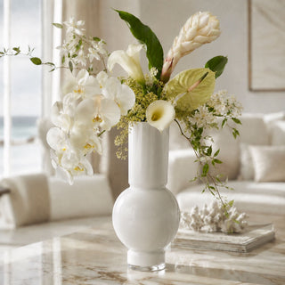 38 Inch Cream Apricot Ginger stem in a Glossy white 20-inch vase with an airy semi-tropical faux floral arrangement of cream apricot ginger, white orchids, pale green anthurium, calla lilies, and delicate flowering vine, styled on a marble coffee table in a serene coastal modern living room.